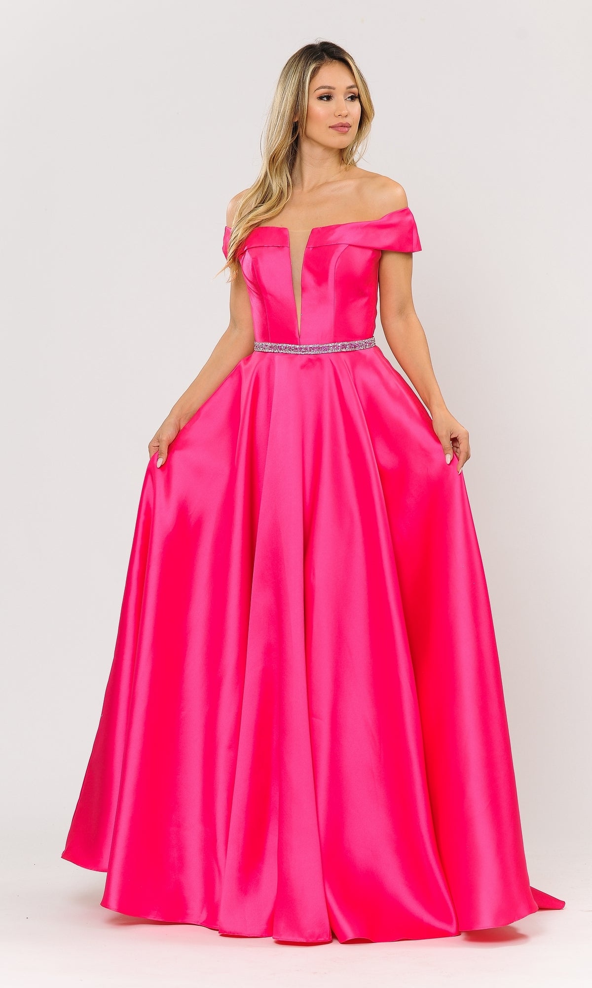 A woman stands against a plain light background wearing the Plunging V-Neck Long Mikado Prom Ball Gown 8680 in bright pink satin with off-the-shoulder sleeves and a beaded waist detail.